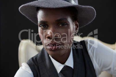 Androgynous man sitting on a chair