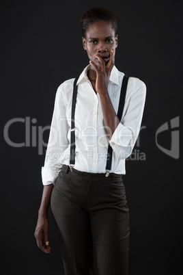 Androgynous man standing with hands on his face