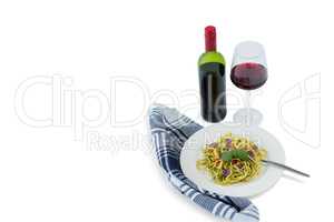 Pasta served in plate by wineglass