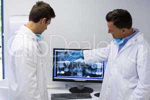 Dentist examining x-ray report on computer
