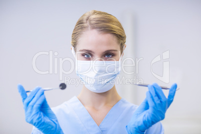 Portrait of female nurse holding dental tools