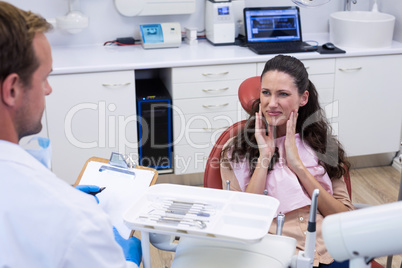 Dentist talking to female patient