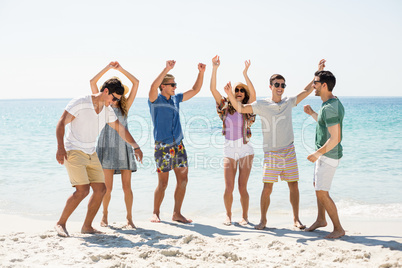 Young friends dancing at beach on sunny day Young friends dancing at beach on sunny day