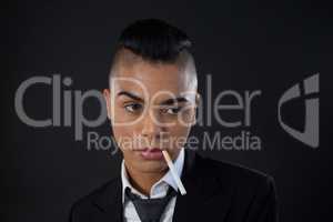 Transgender with cigarette in mouth over black background