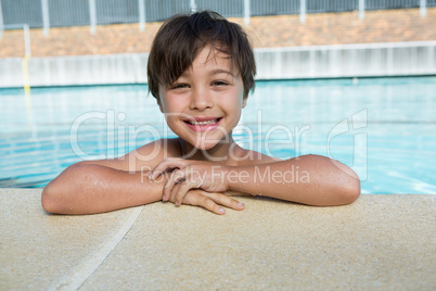 Portrait of young boy relaxing at poolside