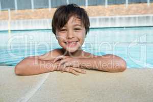 Portrait of young boy relaxing at poolside