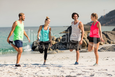 Friends smiling while exercising at beach