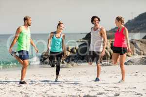 Friends smiling while exercising at beach