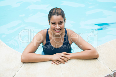 Smiling woman leaning on poolside