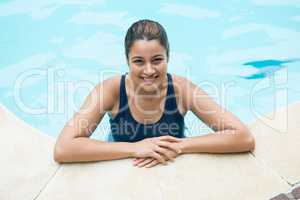 Smiling woman leaning on poolside