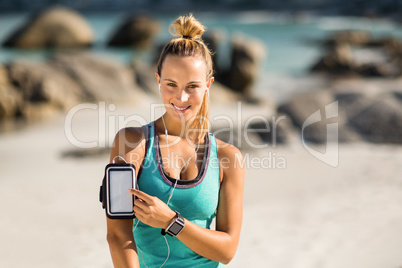 Young woman touching smartphone on armband