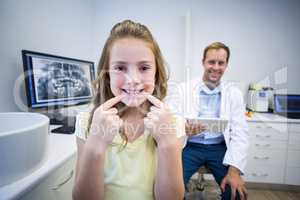 Smiling young woman showing her teeth in dental clinic