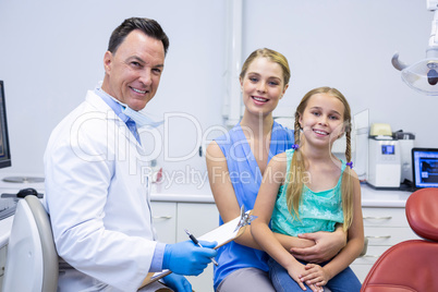 Portrait of smiling dentists and female patient