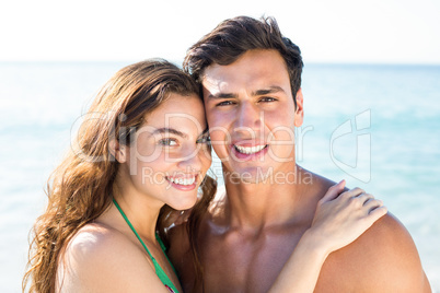 Happy couple embracing on shore at beach