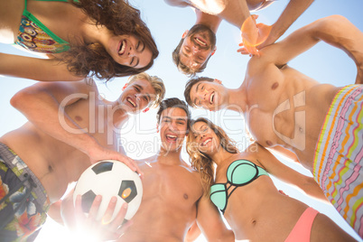 Happy friends with soccer ball at beach