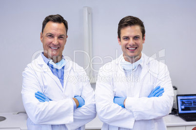 Portrait of happy dentists standing with arms crossed