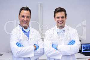 Portrait of happy dentists standing with arms crossed
