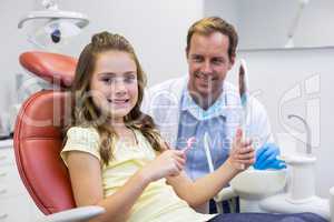 Smiling young patient holding mirror in in dental clinic