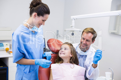 Smiling dentists interacting with young patient