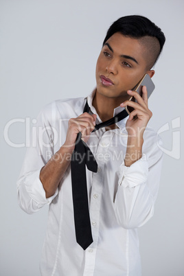 Transgender woman holding tie while using phone