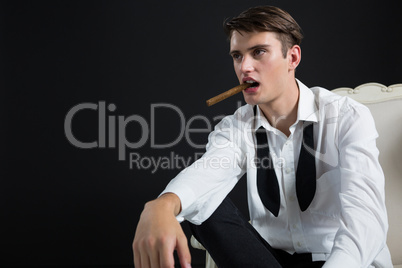 Androgynous man posing with cigar in his mouth