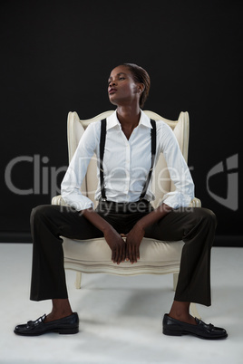 Androgynous man sitting on a chair