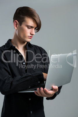 Androgynous man using laptop