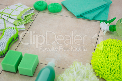 Green cleaning products arranged on tiled floor