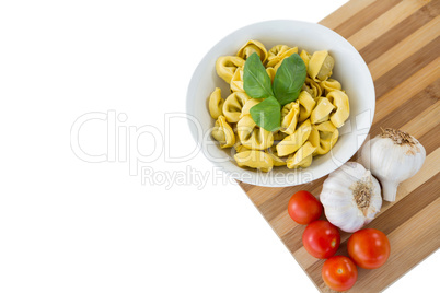 High angle view of pasta served in bowl on cutting board