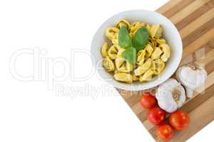 High angle view of pasta served in bowl on cutting board
