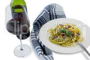 Close up of pasta served in plate by wine