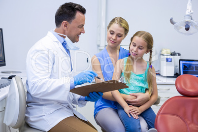 Smiling dentists interacting with female patient