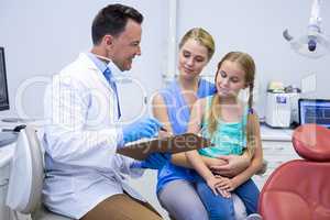 Smiling dentists interacting with female patient