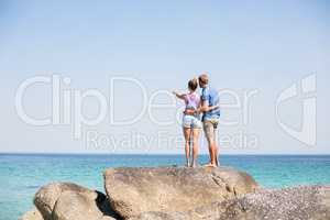 Couple standing on rock by sea