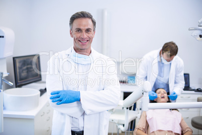 Smiling dentist standing with arms crossed