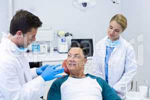 Dentists interacting with a male patient