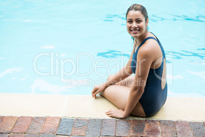 Smiling woman sitting at poolside