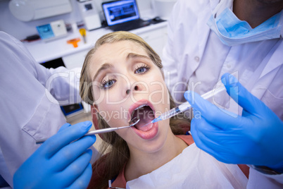Dentists giving anesthesia to female patient