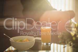 Close up of breakfast on table while woman sitting on sofa