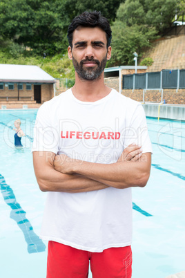 Confident lifeguard standing with arms crossed