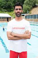 Confident lifeguard standing with arms crossed