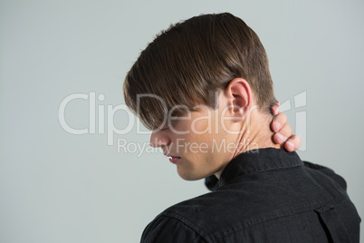 Androgynous man touching his neck