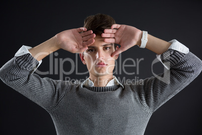 Androgynous man posing with hands on forehead