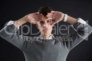 Androgynous man posing with hands on forehead