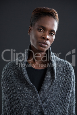 Androgynous man in sweater against grey background