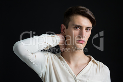 Androgynous man posing with hand on his neck