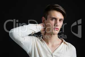 Androgynous man posing with hand on his neck