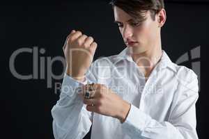 Androgynous man adjusting his hand cuffs