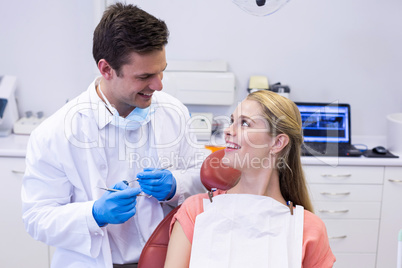 Dentist interacting with female patient while examining