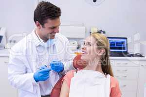 Dentist interacting with female patient while examining